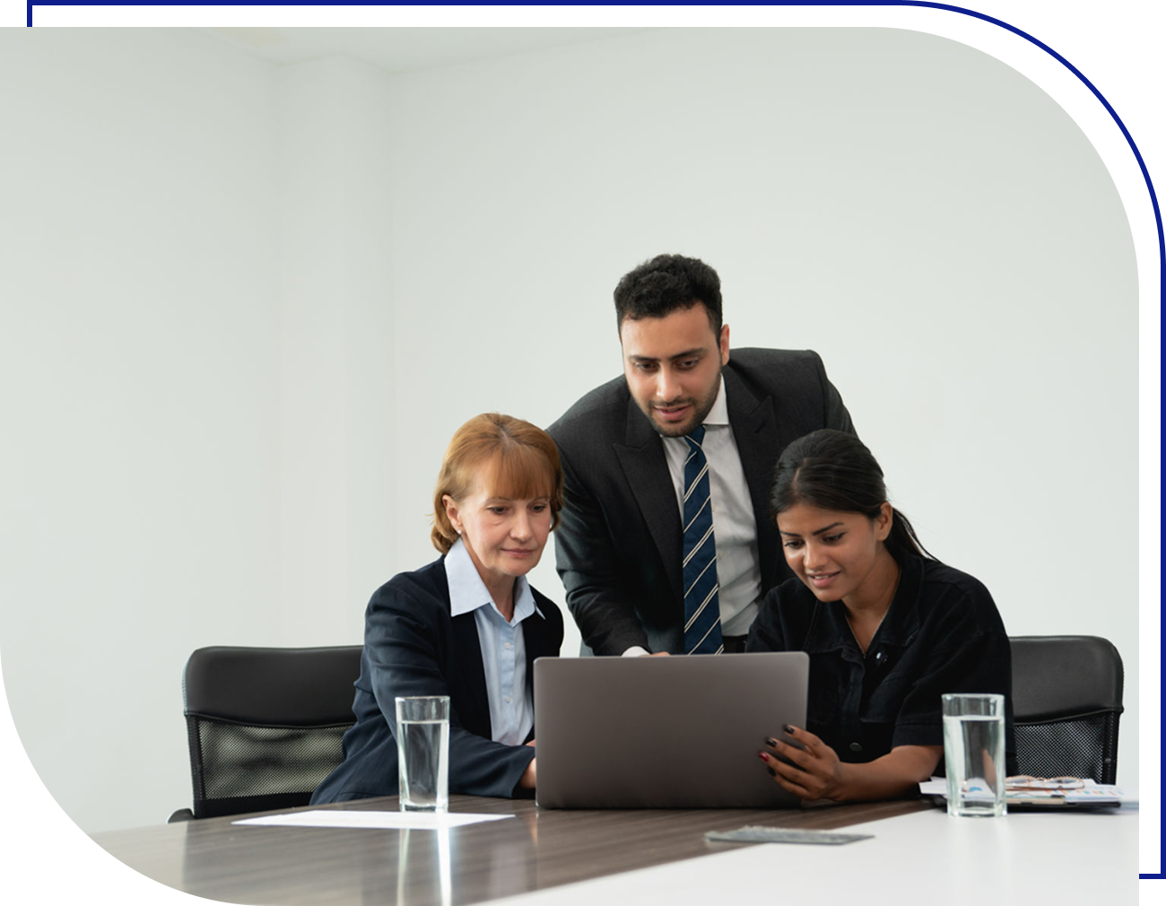 Three colleagues collaborating at a laptop.